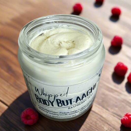Jar of whipped body butter on a wooden surface